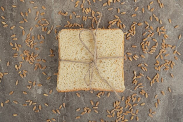 Rebanada de pan tostado con cebada sobre superficie de mármol. Foto de alta calidad