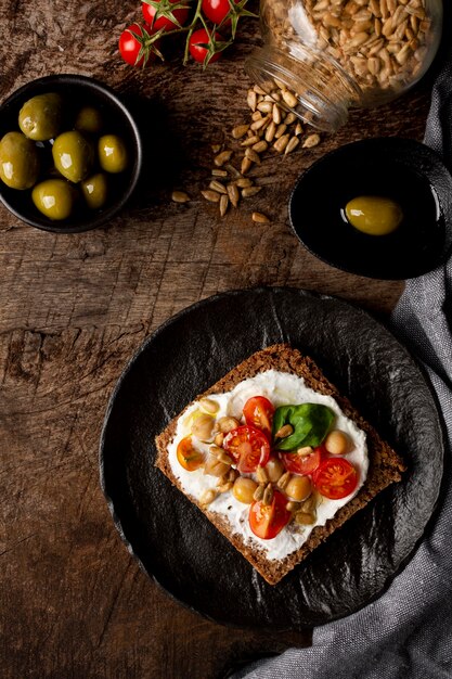 Rebanada de pan tostado delicioso con tomates cherry en la mesa de la cocina