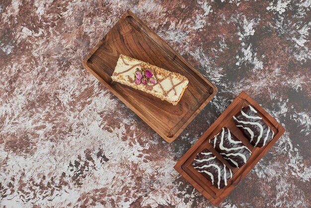 Rebanada de pastel con brownies sobre una tabla de madera.