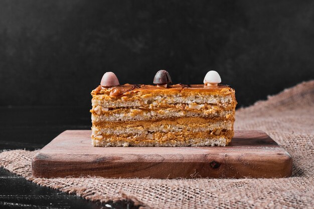 Rebanada de pastel de caramelo en un plato de madera.