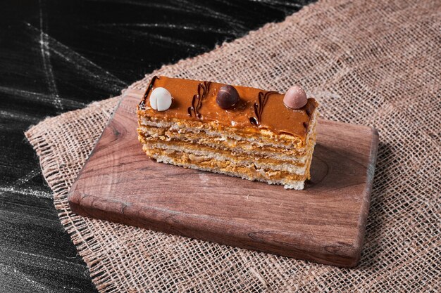 Rebanada de pastel de caramelo en un plato de madera.