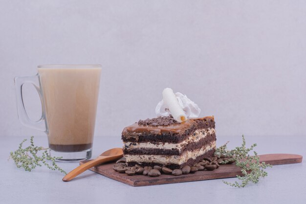 Una rebanada de pastel de caramelo con un vaso de capuchino