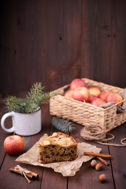 Rebanada de pastel con cesta de manzanas y castañas