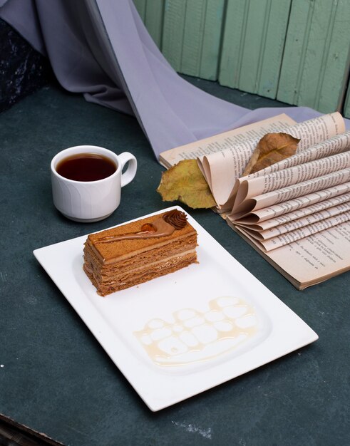 Una rebanada de pastel de chocolate de cacao con una taza de té.