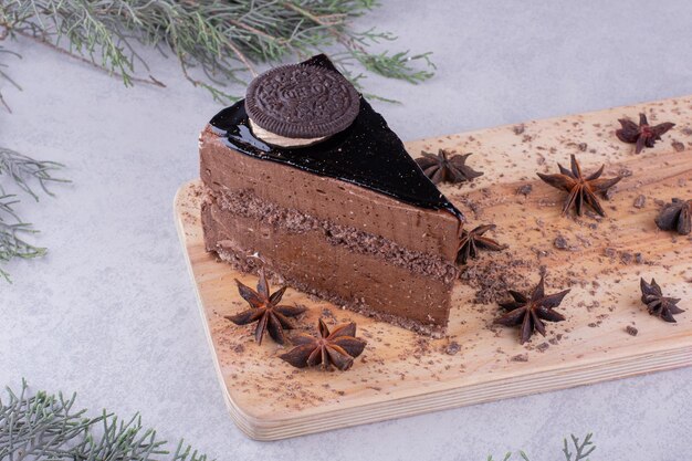 Rebanada de pastel de chocolate con clavo de olor sobre tabla de madera. Foto de alta calidad