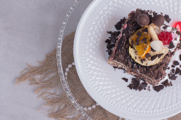 Rebanada de pastel de chocolate en un plato blanco con perlas.