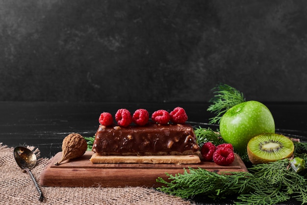 Rebanada de pastel de chocolate en un plato de madera.