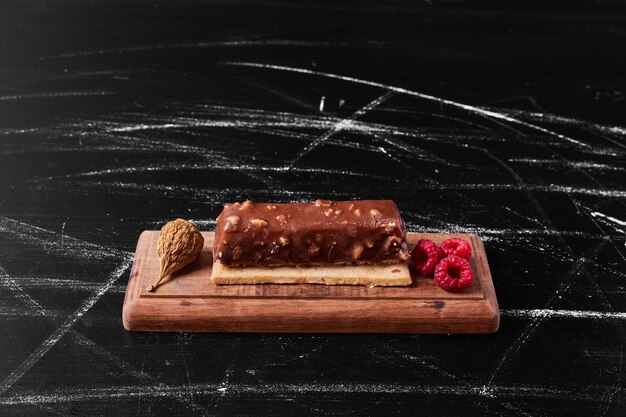 Rebanada de pastel de chocolate en un plato de madera.