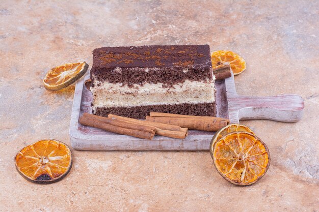 Una rebanada de pastel de chocolate con rodajas de naranja secas alrededor