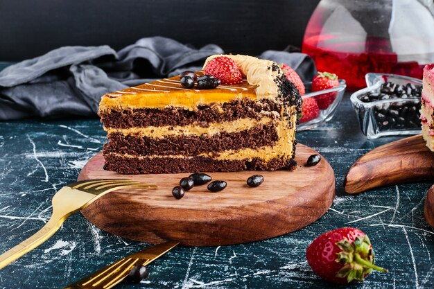 Una rebanada de pastel de chocolate sobre una tabla de madera.