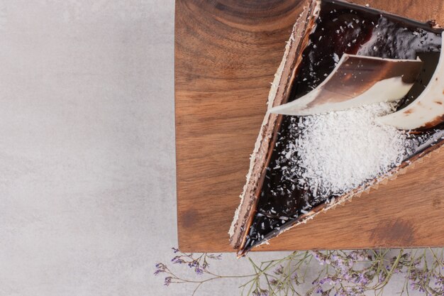 Rebanada de pastel de chocolate sobre tabla de madera.