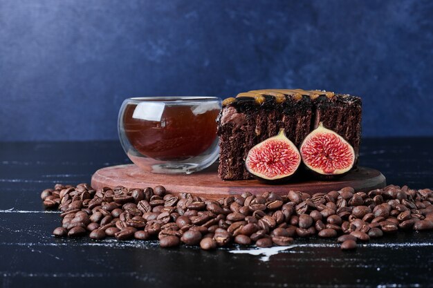 Rebanada de pastel de chocolate con una taza de bebida.