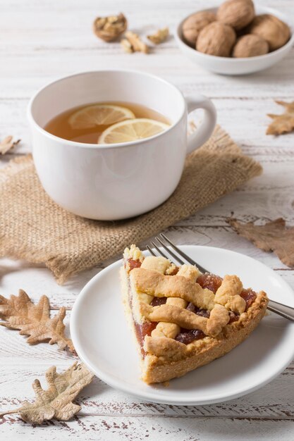 Rebanada de pastel delicioso de alto ángulo y taza de té