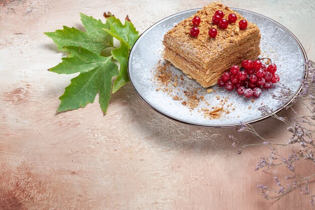 rebanada de pastel con frutos rojos sobre gris