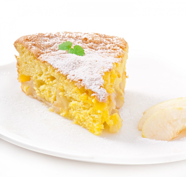 Rebanada de pastel de manzana en un plato decorado con hojas de menta