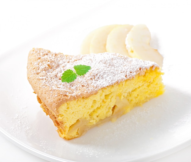 Rebanada de pastel de manzana en un plato decorado con hojas de menta