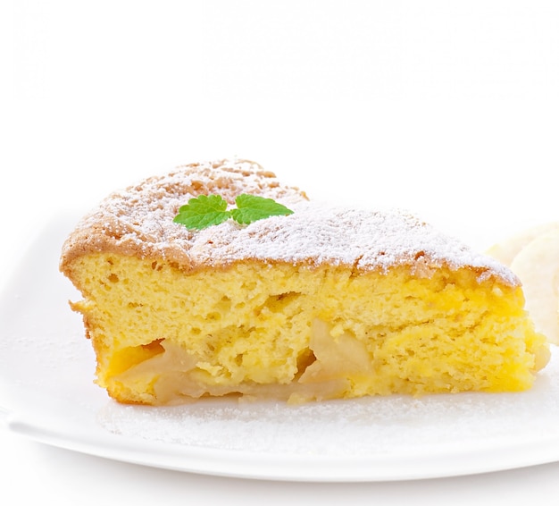 Rebanada de pastel de manzana en un plato decorado con hojas de menta