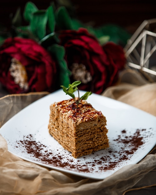 Una rebanada de pastel de medovik con hojas de menta.