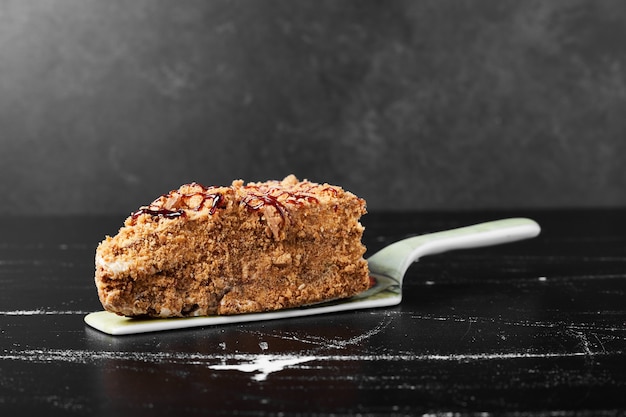 Una rebanada de pastel de miel en la espátula.