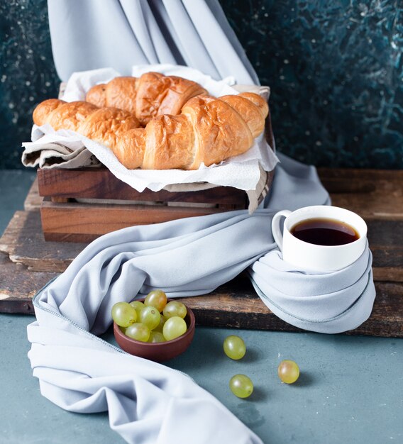 Una rebanada de pastel de queso con ganache de chocolate con una taza de té.