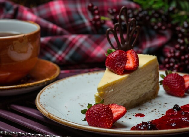 Rebanada de pastel de queso de vainilla con fresas.