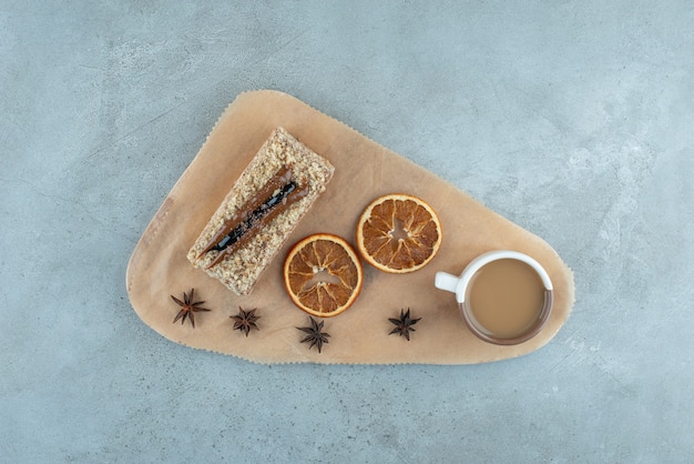 Rebanada de pastel con rodajas de naranja y café sobre tabla de madera. Foto de alta calidad