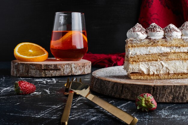 Una rebanada de pastel de tiramisú con un vaso de limonada.