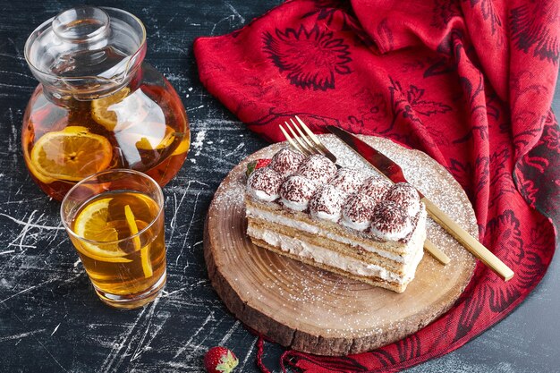 Una rebanada de pastel de tiramisú con un vaso de limonada.