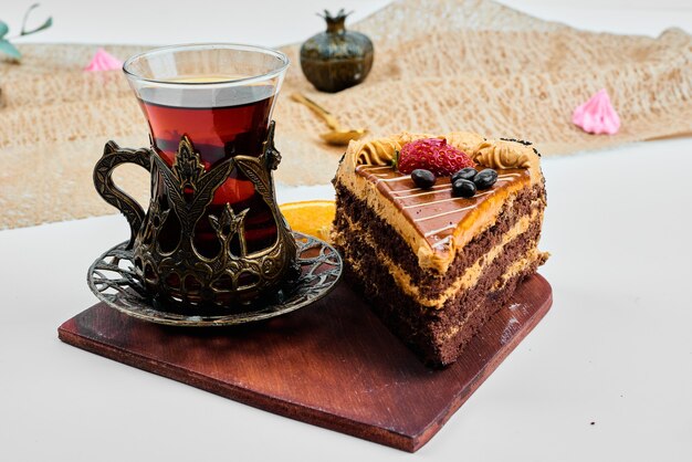 Rebanada de pastel con un vaso de té.