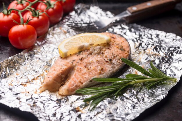 Rebanada de pescado y tomate de alta vista