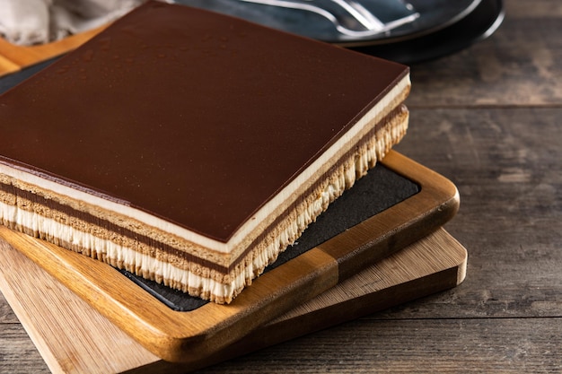 Rebanada de postre de pastel de ópera en mesa de madera