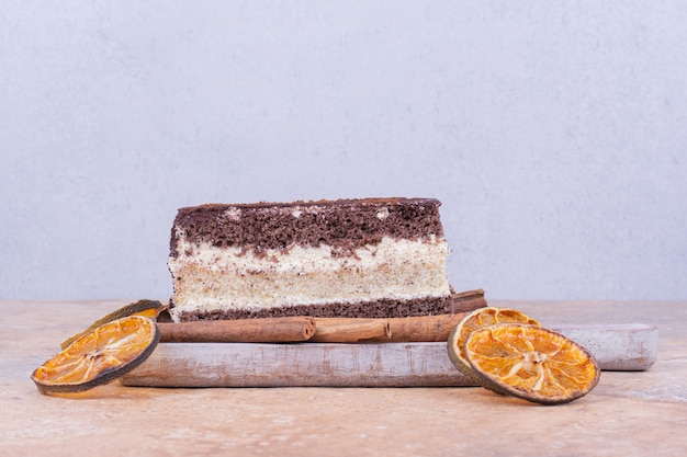 Foto gratuita una rebanada de tarta de chocolate con rodajas de naranja y canela