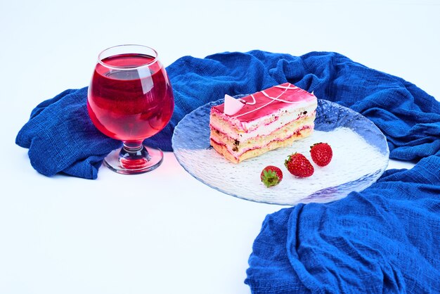 Una rebanada de tarta de frambuesa con una copa de vino.