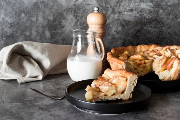 Rebanada de tarta de manzana vista frontal en un plato con leche
