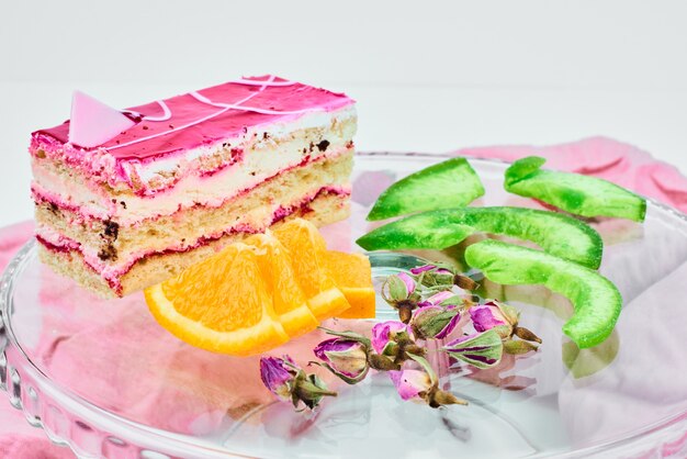 Una rebanada de tarta de queso de fresa con frutas alrededor.