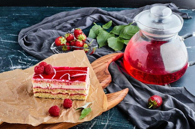 Una rebanada de tarta de queso de fresa con un tarro de jugo.