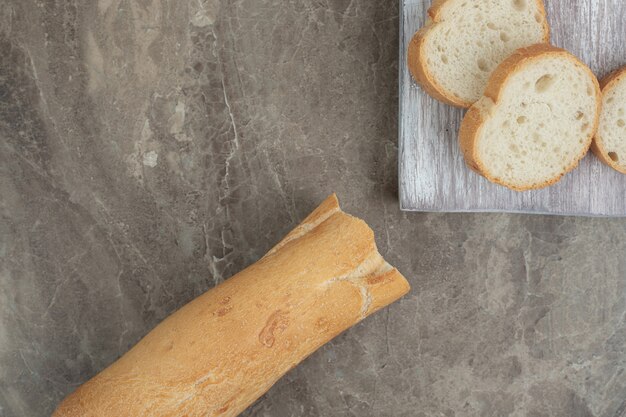 Rebanadas de baguette fresco sobre fondo de mármol. Foto de alta calidad