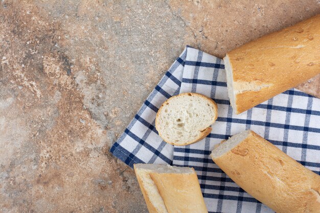 Rebanadas de baguette fresco sobre mantel rayado