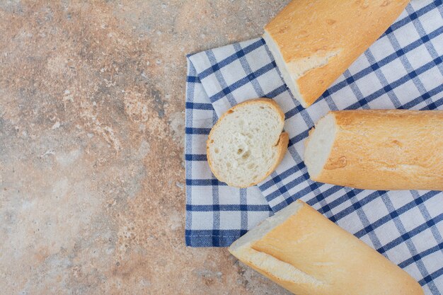 Rebanadas de baguette fresco sobre mantel rayado