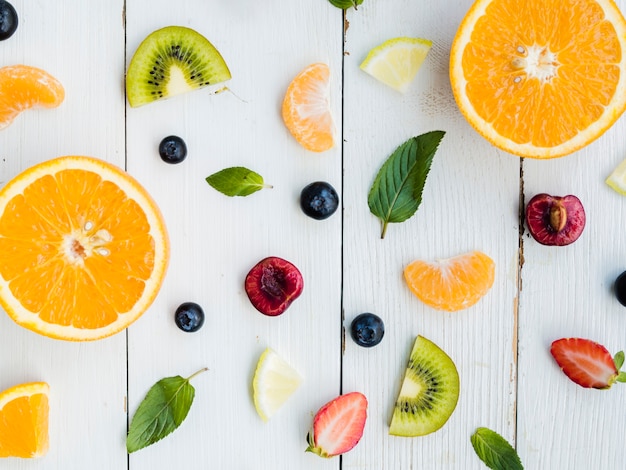 Foto gratuita rebanadas de fruta brillante tropical fresca sobre fondo de madera