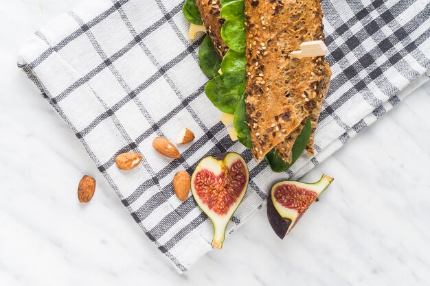 Rebanadas de fruta de higo fresco y almendras cerca de un perrito caliente sobre una servilleta en el mostrador de la cocina