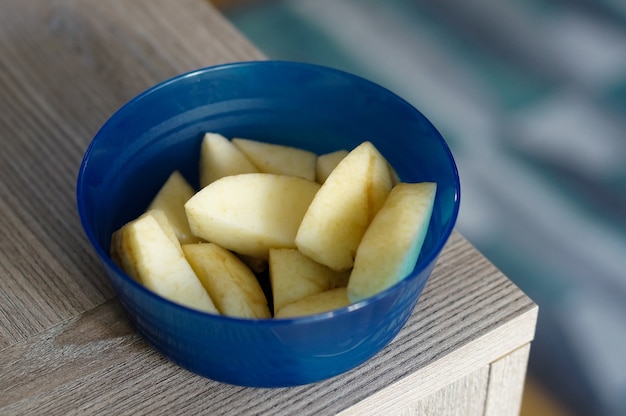 Rebanadas de manzanas en el recipiente azul sobre la mesa