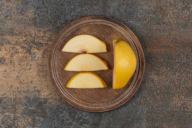 Rebanadas de membrillo amarillo sobre tabla de madera