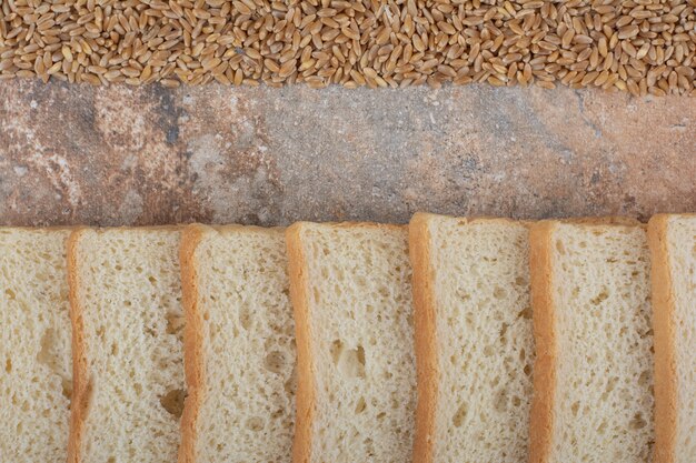 Rebanadas de pan blanco con cebada sobre fondo de mármol