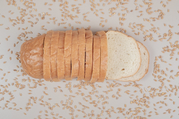 Foto gratuita rebanadas de pan blanco fresco con granos de avena sobre superficie blanca