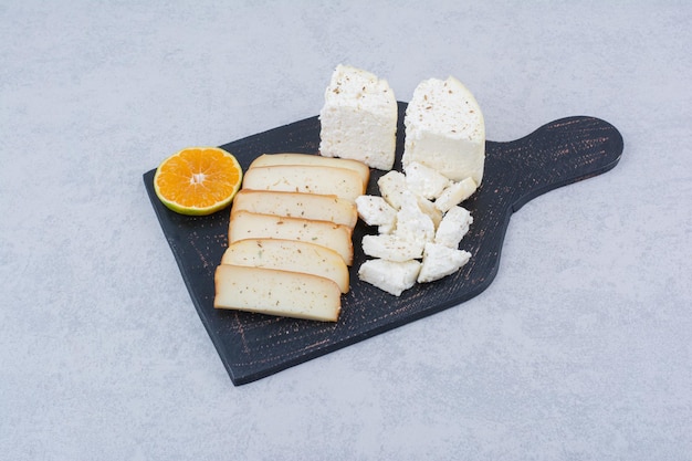 Rebanadas de pan blanco con rodaja de naranja sobre tabla de cortar. Foto de alta calidad
