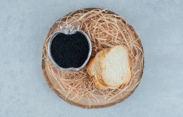 Rebanadas de pan con caviar negro en una taza de cristal.