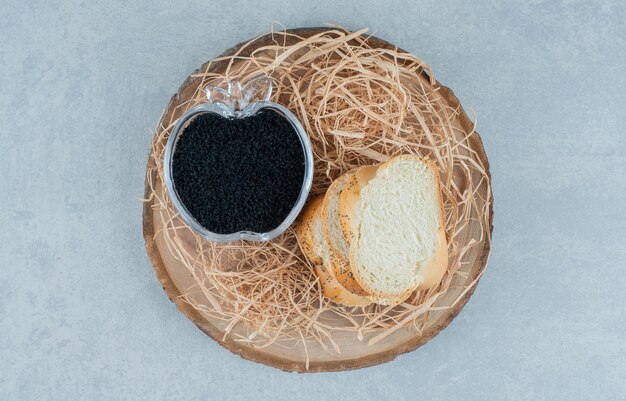 Rebanadas de pan con caviar negro en una taza de cristal.