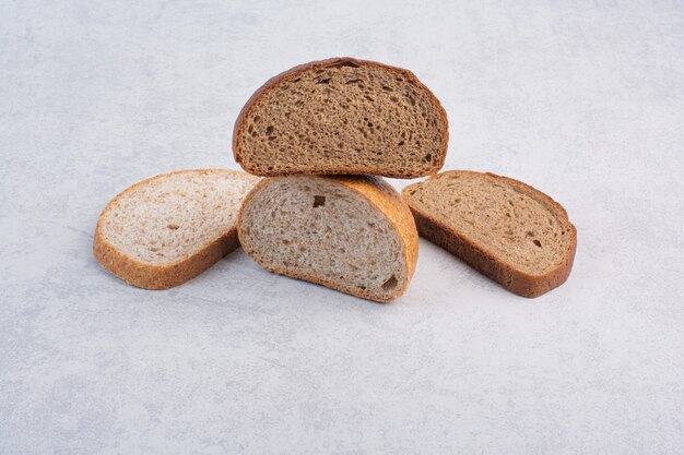 Rebanadas de pan de centeno y negro sobre la superficie de piedra