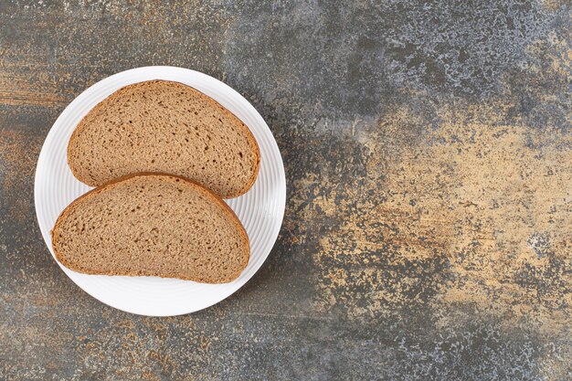 Rebanadas de pan de centeno en la placa blanca.